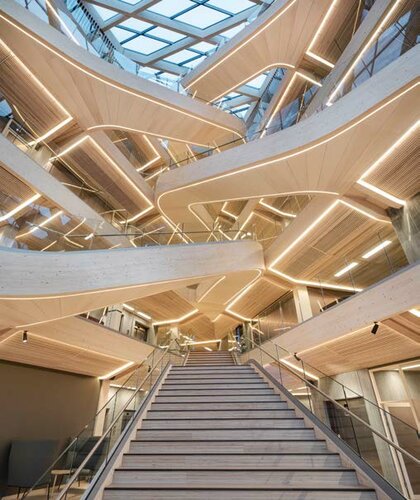 Wie eine Raumskulptur füllt die geschwungene Haupttreppe den Luftraum des Foyers der SR Bank von Stavanger. Sie ist ein Ingenieurskunstwerk und soll auch eine der größten Holztreppen der Welt sein.