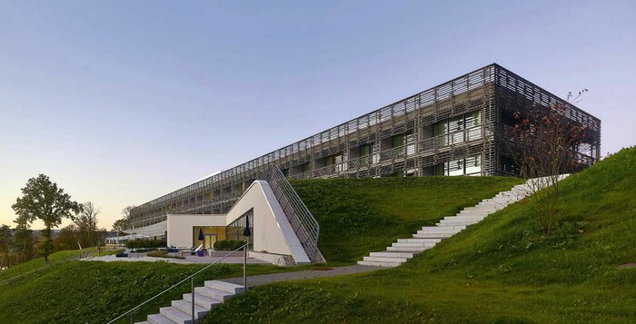 Moderne Zimmer am überaus besonderen Standort: Der futuristische Bau aus Beton, Glas und Holz ragt mystisch aus der hügeligen Landschaft hervor.