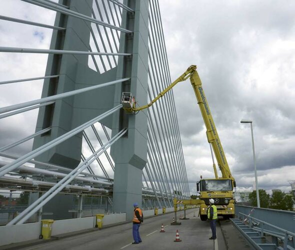 Brückenprüfer untersuchen mithilfe eines Steigers eine Brücke bei Höchst.