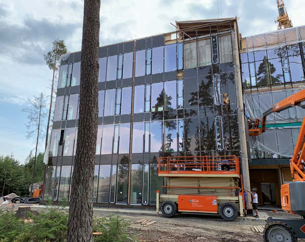 Vom Erdgeschoss bis zum dritten Obergeschoss handelt es sich um einen Holzskelettbau mit vorgehängter Glasfassade und sogenannten "Screenanlagen" zur Verschattung.